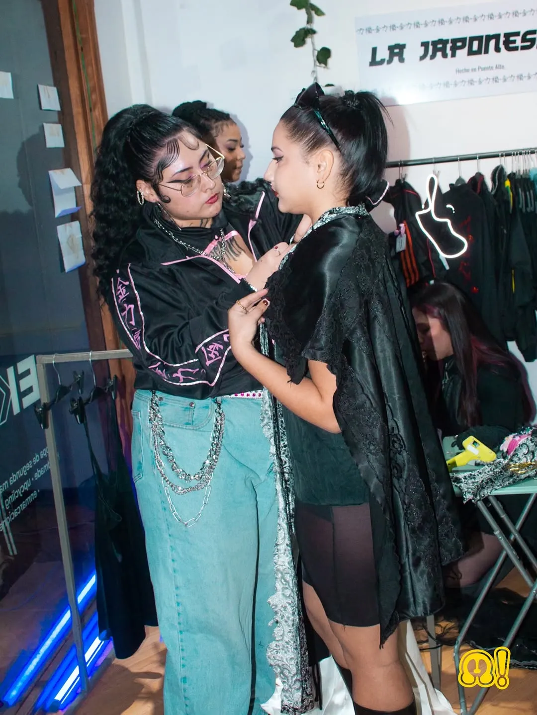 La dueña de La Japonesssa ajustando una prenda a una modelo en su showroom